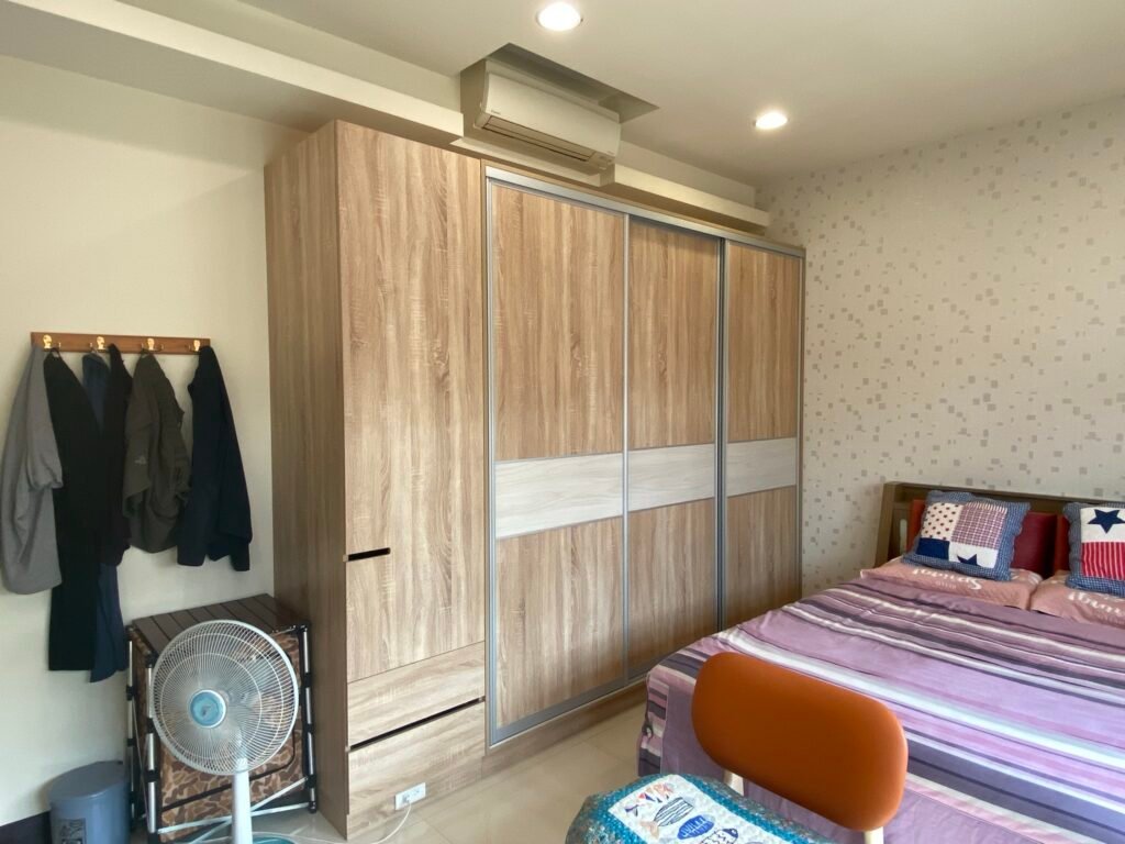 臥室空間搭配木紋系統衣櫃與滑門設計，兼具收納機能與空間利用的透天住宅規劃。