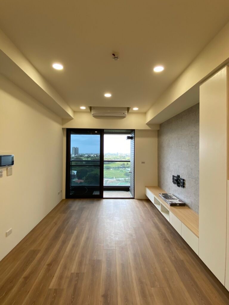 簡約客廳設計，清水模電視牆搭配懸空電視櫃與木地板，營造明亮舒適空間。